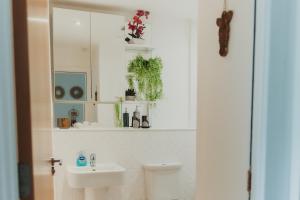 a bathroom with a sink and a toilet and a mirror at Lovely Bohemian Apartment in Heart of City Life in Glasgow