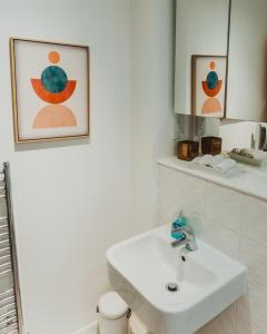 a white bathroom with a sink and a mirror at Lovely Bohemian Apartment in Heart of City Life in Glasgow