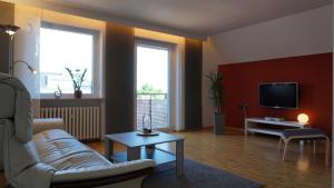 a living room with a couch and a tv at Ferienwohnung an der Klinge in Wiesenbronn +17 photos