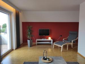 a living room with a tv and a chair at Ferienwohnung an der Klinge in Wiesenbronn
