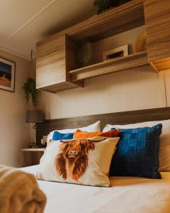 Un dormitorio con una cama con almohadas. en Cosy Caravan Craig Tara, en Ayr