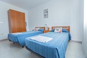Dos camas en una habitación de hospital con sábanas azules. en Apartamentos Aigua Oliva, en Vinarós 23 fotos más