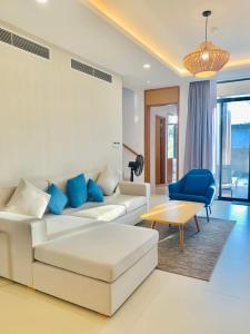 sala de estar con sofá blanco y silla azul en Cam Ranh Villa en Nha Trang