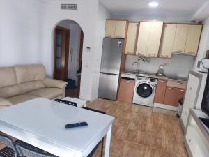 een kleine woonkamer met een bank en een keuken bij Apartamentos el rebalaje III in Roquetas de Mar