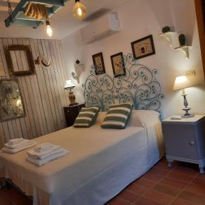 - une chambre avec un grand lit et une grande tête de lit dans l'établissement TRULLO PIETRAPOESIA, à Ostuni