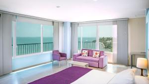 a bedroom with purple furniture and large windows at Santorini Kima Beach Resort in Santa Marta