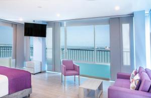 a bedroom with purple furniture and a view of the ocean at Santorini Kima Beach Resort in Santa Marta +62 photos