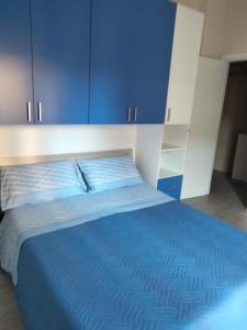 1 dormitorio con 1 cama azul y armarios azules en Casa Vacanza al mare, en Isola di Capo Rizzuto