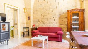 sala de estar con sofá rojo y mesa en ACAMYA LUXE Apartment en Acaya