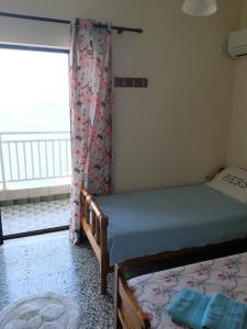 a bedroom with two beds and a window at Stamatia's House in Haraki