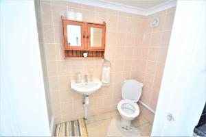 a bathroom with a toilet and a sink at Adorable 1 bedroom guest house with free parking. in Bromley