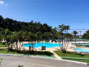 vistas a la piscina desde el balcón de un complejo en Apartamento até 10 pessoas na enseada Guarujá em condomínio clube praia piscinas salão jogos quadra futebol campo parquinho brinquedos Wi-fi Home office, en Guarujá