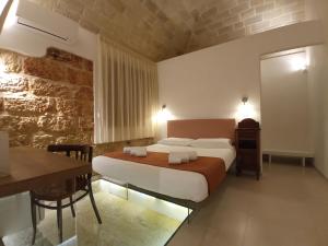 a hotel room with a bed and a table and a desk at Ricordi Siciliani - Charme B&B in San Vito lo Capo