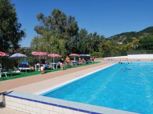 a swimming pool with people sitting on chairs and umbrellas at TRE METR SOPRA IL CIELO ''AcquAria'' in Felitto
