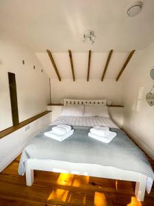 a bedroom with a bed with two towels on it at Holmdale Holiday Cottages in Rye