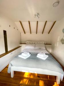 ein Schlafzimmer mit einem Bett mit zwei Handtüchern darauf in der Unterkunft Holmdale Holiday Cottages in Rye