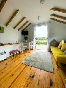 ein Wohnzimmer mit einem gelben Sofa und einem Tisch in der Unterkunft Holmdale Holiday Cottages in Rye