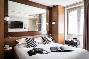 a bedroom with a large bed with black and white pillows at Holiday Inn Paris Elysées, an IHG Hotel in Paris