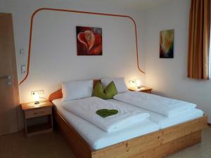 1 cama en una habitación con 2 mesas y 2 lámparas en Haus Ausblick en Tux