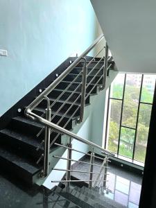 una escalera de metal en un edificio con una gran ventana en HOTEL AIRPORT KK, en Nagpur
