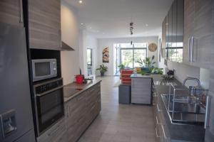 een keuken met roestvrijstalen apparatuur en een woonkamer bij Villa L'Alameda Spa Billard Paris Centre 35min in Verrières-le-Buisson