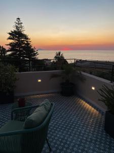 a patio with a view of the ocean at sunset at NoOne Tropea Guesthouse in Tropea
