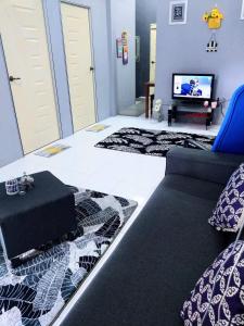 a living room with a couch and a tv at Azie Homestay in Kota Bharu