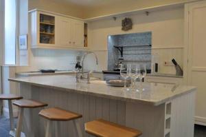 una cocina con una barra con copas de vino. en Gorgeous Apartment only yards from Polzeath Beach en Wadebridge