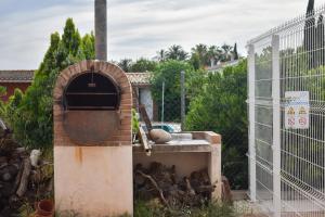 a brick oven in a yard next to a fence at Salvadora Luminosa in Murcia