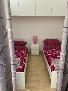 2 camas en una habitación con rojo y blanco en Boschetto en Riva del Garda