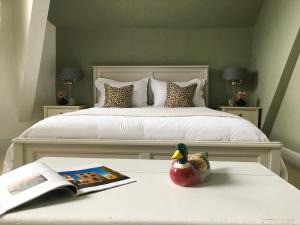 a bedroom with a bed with a book and a duck on a table at Le Château Aspet B&B in Aspet