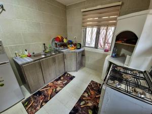 a kitchen with a sink and a stove at Rainbow House in Amman