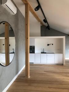 a kitchen with white cabinets and a round mirror at Boutique REZIDENCE BAAR in Nový Jičín