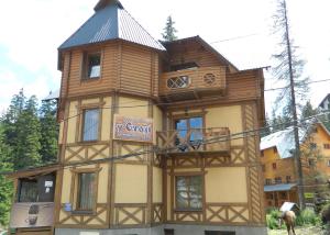 un grand bâtiment en bois avec un panneau. dans l'établissement U Stozi Hotel, à Dragobrat