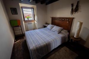 um quarto com uma cama com uma colcha listrada e uma janela em Mujika Etxea em Manurga
