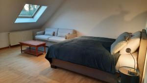 a bedroom with a bed and a chair and a couch at The Kettle House - Manor in Sint-Pieters-Leeuw