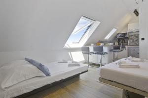 een slaapkamer met 2 bedden en een keuken met een raam bij Beautiful modern studio with a view on the ocean - Biarritz - Welkeys in Biarritz