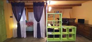 a room with a green book shelf and purple curtains at Casa Manuel y Ana María. 