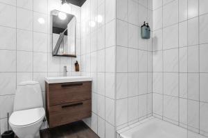 een witte badkamer met een toilet en een wastafel bij Gerður Apartments in Reykjavík