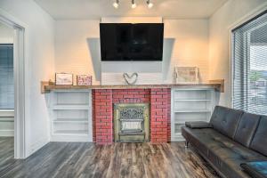 a living room with a fireplace with a flat screen tv at Charming and Quaint El Paso House with Backyard! in El Paso