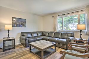 een woonkamer met een leren bank en een tafel bij Ideally Located Glen Cove Apartment! in Glen Cove