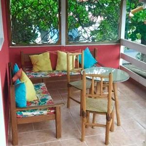 a porch with two chairs and a table and a bench at Portal Cores in Porto De Galinhas