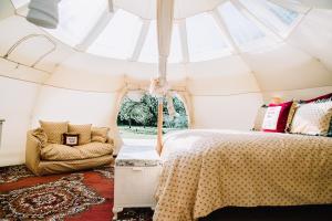 a bedroom in a tent with a bed and a chair at Appleblossom Yurt in Alkborough