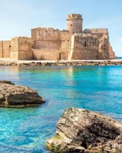 un castillo en la orilla de un cuerpo de agua en Casa Vacanza al mare, en Isola di Capo Rizzuto