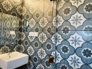 a bathroom with a sink and blue and white tiles at HOTEL AIRPORT KK in Nagpur