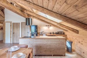 cocina con techos de madera y mesa de madera en Appartement La Pause de l'Ours - Welkeys, en Combloux