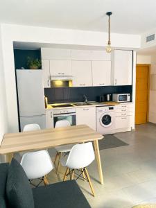 - une cuisine avec une table en bois et des placards blancs dans l'établissement Apartment Rosario in Malaga center, à Malaga