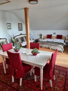 a dining room with a white table and red chairs at Apartmán Mikulov in Mikulov