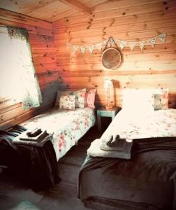 1 dormitorio con 2 camas en una cabaña de madera en La Papillon Glamping, en La Châtre