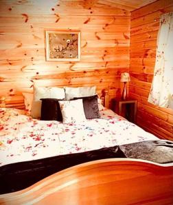 um quarto com uma cama num chalé de madeira em La Papillon Glamping em La Châtre